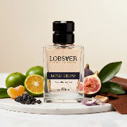 Perfume bottle labeled 'Lobster Royal Cruise' with fruits and leaves on a marble surface