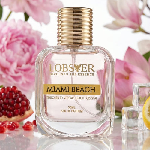 Perfume bottle labeled 'Lobster Miami Beach' with pink flowers and pomegranates in the background
