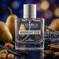 Perfume bottle labeled 'Midnight Tide' by Lobster with pears, lavender, and cinnamon on a reflective surface.