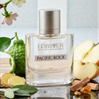 Lobster Pacific Rock perfume bottle with ingredients on a reflective surface