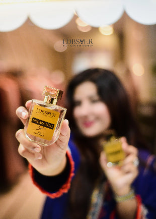 Person holding a Lobster perfume bottle with a blurred background