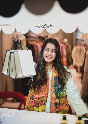 Woman holding a shopping bag with 'LOBSTER' branding in the background