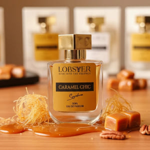 Perfume bottle labeled 'Caramel Chic' by Lobster on a wooden surface with caramel and pecans.